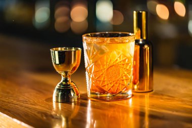 Üç renkli kokteyller büyük gözlüklü bir klasik bar ortamı içinde belgili tanımlık geçmiş bulanık içki şişeleri düzinelerce.