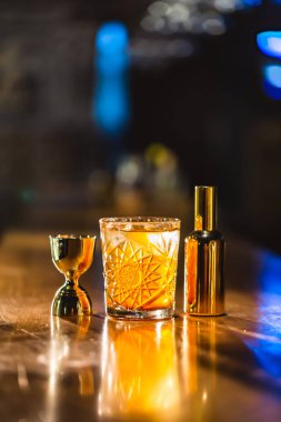 Üç renkli kokteyller büyük gözlüklü bir klasik bar ortamı içinde belgili tanımlık geçmiş bulanık içki şişeleri düzinelerce.