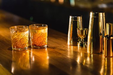 Üç renkli kokteyller büyük gözlüklü bir klasik bar ortamı içinde belgili tanımlık geçmiş bulanık içki şişeleri düzinelerce.