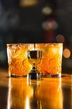 Üç renkli kokteyller büyük gözlüklü bir klasik bar ortamı içinde belgili tanımlık geçmiş bulanık içki şişeleri düzinelerce.