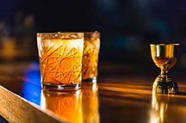 Üç renkli kokteyller büyük gözlüklü bir klasik bar ortamı içinde belgili tanımlık geçmiş bulanık içki şişeleri düzinelerce.