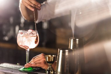 Üç renkli kokteyller büyük şarap gözlük bir klasik bar ortamı içinde belgili tanımlık geçmiş bulanık içki şişeleri düzinelerce.
