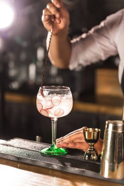Üç renkli kokteyller büyük şarap gözlük bir klasik bar ortamı içinde belgili tanımlık geçmiş bulanık içki şişeleri düzinelerce.