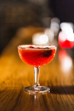 Üç renkli kokteyller büyük gözlüklü bir klasik bar ortamı içinde belgili tanımlık geçmiş bulanık içki şişeleri düzinelerce.