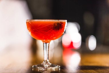 Üç renkli kokteyller büyük gözlüklü bir klasik bar ortamı içinde belgili tanımlık geçmiş bulanık içki şişeleri düzinelerce.