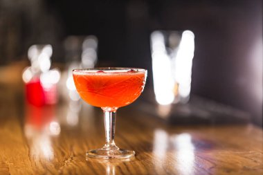 Üç renkli kokteyller büyük gözlüklü bir klasik bar ortamı içinde belgili tanımlık geçmiş bulanık içki şişeleri düzinelerce.