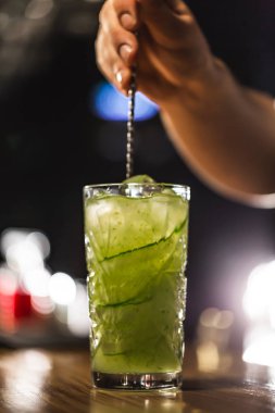 Üç renkli kokteyller büyük gözlüklü bir klasik bar ortamı içinde belgili tanımlık geçmiş bulanık içki şişeleri düzinelerce.