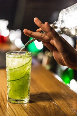 Üç renkli kokteyller büyük gözlüklü bir klasik bar ortamı içinde belgili tanımlık geçmiş bulanık içki şişeleri düzinelerce.