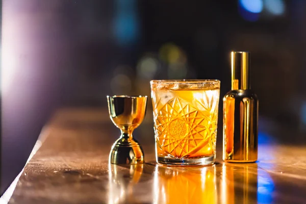 Üç renkli kokteyller büyük gözlüklü bir klasik bar ortamı içinde belgili tanımlık geçmiş bulanık içki şişeleri düzinelerce.