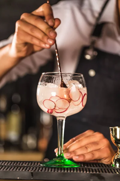 Üç renkli kokteyller büyük şarap gözlük bir klasik bar ortamı içinde belgili tanımlık geçmiş bulanık içki şişeleri düzinelerce.