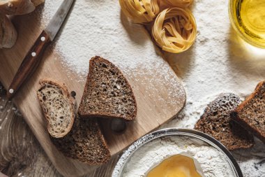 Ev yapımı kepekli ekmek buğday unu ile ahşap bir arka plan üzerine dilimlenmiş. Ton görünümü
