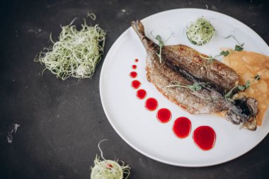 Kızarmış balık otlar ve limon, closeup ile beyaz plaka