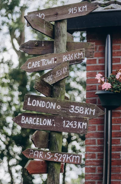 Wooden navigation signpost with  arrows -Paris, Barcelona, London, Cape Town