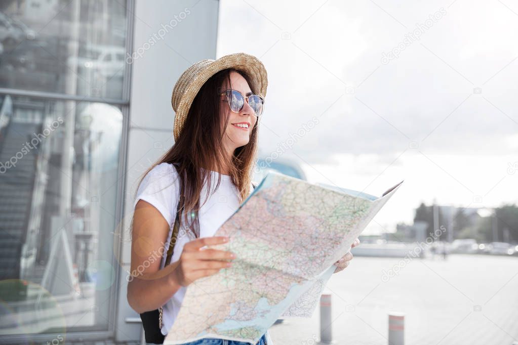 Young smiled tourist at window  looking upwards with a map in her hand.traveling along Europe, freedom and active lifestyle concep