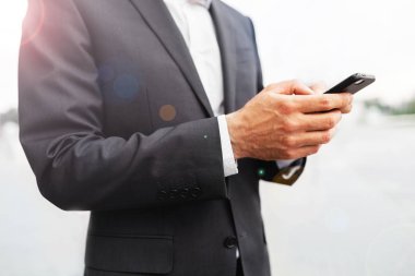 Mobil akıllı telefon kullanan bir adam kapatın. İş ve bilgi teknolojisi kavramı. şehir içinde belgili tanımlık geçmiş ile ayakta sokak