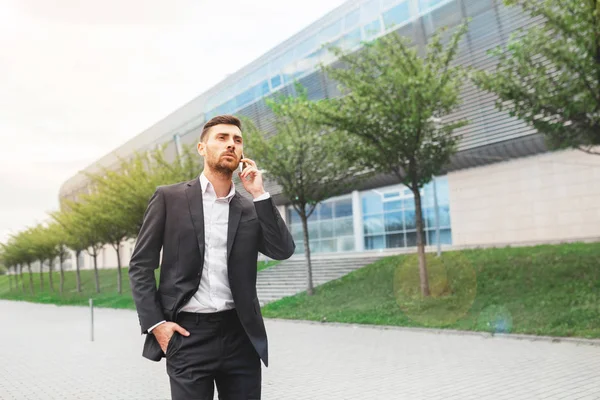 Joven Hombre Negocios Sonriente Hablando Por Teléfono Celular Caminando Cerca — Foto de Stock