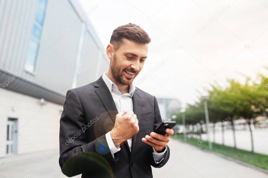 Winning call. Confident and successful businessman rejoices successful deal talking on a cell phone.