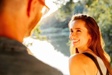 Yakışıklı adam ve esmer kız doğal zemin üzerine güzel bir sıcak gün batımı üzerinde yürüme. çocuk elini tutarak kız yol açar.