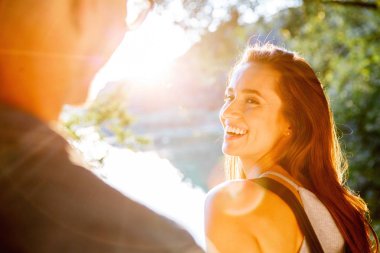 Yakışıklı adam ve esmer kız doğal zemin üzerine güzel bir sıcak gün batımı üzerinde yürüme. çocuk elini tutarak kız yol açar.
