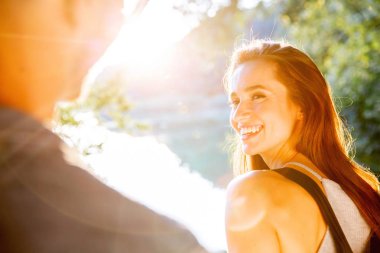 Yakışıklı adam ve esmer kız doğal zemin üzerine güzel bir sıcak gün batımı üzerinde yürüme. çocuk elini tutarak kız yol açar.