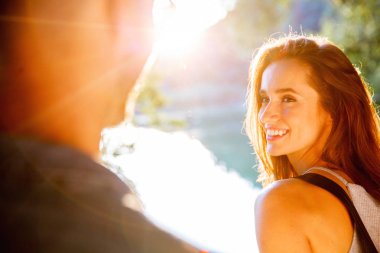 Yakışıklı adam ve esmer kız doğal zemin üzerine güzel bir sıcak gün batımı üzerinde yürüme. çocuk elini tutarak kız yol açar.