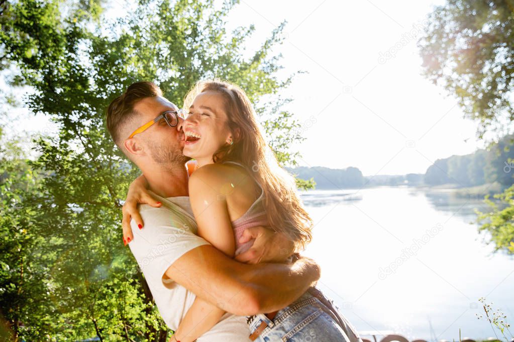 wonderful young couple hug and enjoy life together with natural outdoor laisure activity lifestyle during the summer and the sunset in backlight. 