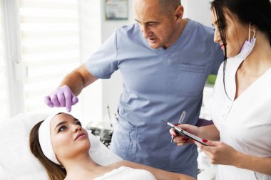 Güzellik uzmanı pembe eldiven yüzü güzel, genç kadını estetik kliniği yordamda daha önce incelenmesi. Kozmetik ve profesyonel cilt bakımı. Cilt Bakımı. Yüksek çözünürlük