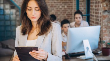 Ofiste arkasında ekibi ile tablet kullanarak rahat iş kadını. başlangıç