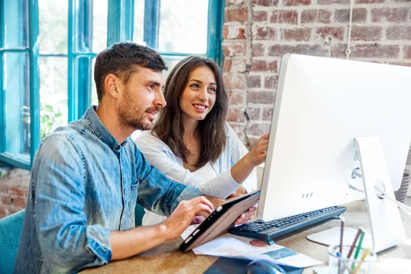 Güneşli ofis dizüstü bilgisayar üzerinde çalışan iki genç arkadaşları. Kağıt belgeleri holding ve defter ekranda gösteren kadın. Horizontal.Blurred background.startu