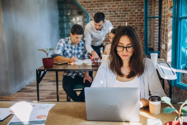Genç sakallı işkadını kot gömlek Office masada oturuyor ve çizelgeler, grafikler ve diyagramlar üzerinde ekran ile laptop kullanıyor. Adam working.startu