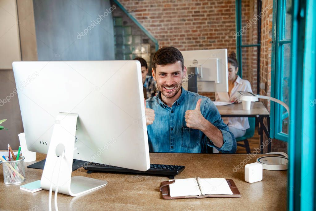happy young businessman  working on laptop and shows that everything is fine,headshot portrait.startup