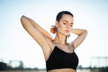 Gündoğumu ile güneşin içinde belgili tanımlık geçmiş vasıl uzanan bir fitness kadın profili silüeti. Açık havada kadar ısınma sağlıklı genç bir kadın. O onun kol ve bacak Germe.