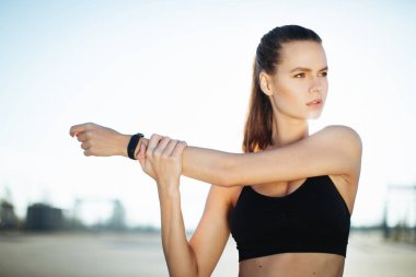 Gündoğumu ile güneşin içinde belgili tanımlık geçmiş vasıl uzanan bir fitness kadın profili silüeti. Açık havada kadar ısınma sağlıklı genç bir kadın. O onun kol ve bacak Germe.