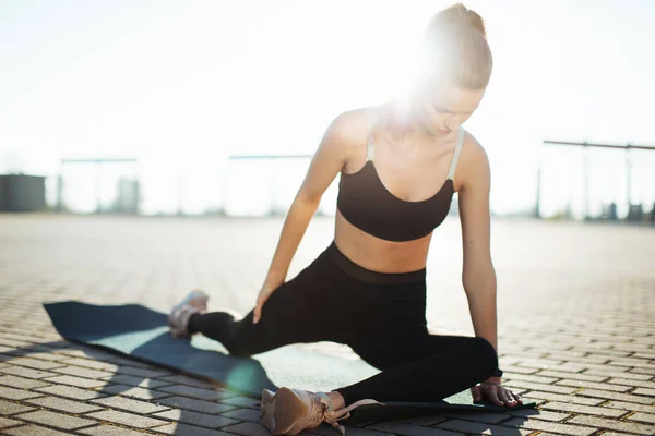 Tired fitness woman wipes sweat from forehead, feels fatigue after active cardio workout, does fitness exercise, has serious expression into distance