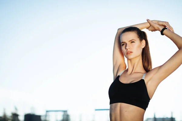Gündoğumu ile güneşin içinde belgili tanımlık geçmiş vasıl uzanan bir fitness kadın profili silüeti. Açık havada kadar ısınma sağlıklı genç bir kadın. O onun kol ve bacak Germe.