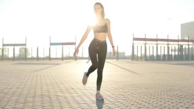 Gündoğumu ile güneşin içinde belgili tanımlık geçmiş vasıl uzanan bir fitness kadın profili silüeti. Açık havada kadar ısınma sağlıklı genç bir kadın. O onun kol ve bacak Germe.