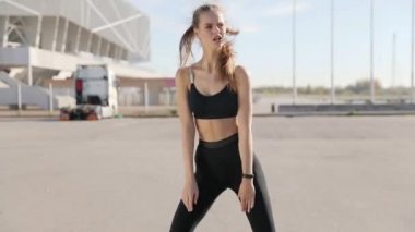 Gündoğumu ile güneşin içinde belgili tanımlık geçmiş vasıl uzanan bir fitness kadın profili silüeti. Açık havada kadar ısınma sağlıklı genç bir kadın. O onun kol ve bacak Germe.