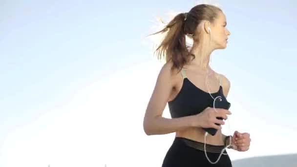 一个健身妇女的轮廓 在日出时伸展 背景是太阳 健康的年轻女子在户外热身 她正在伸展她的胳膊和腿 — 图库视频影像