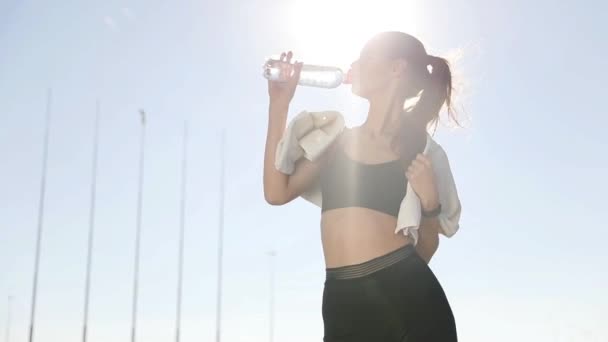 Silueta profilu ženy fitness táhnoucí se na východ slunce na pozadí. Zdravá mladá žena rozcvička venku. Ona je natahovat ruce a nohy.