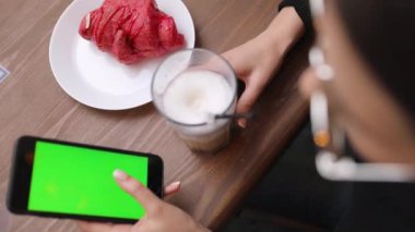 Beyaz gömlek giymiş ve modern akıllı telefon, cep telefonu dışında ağır çekim kısa mesaj yazarak profesyonel kadın işveren kullanarak güzel genç kadın