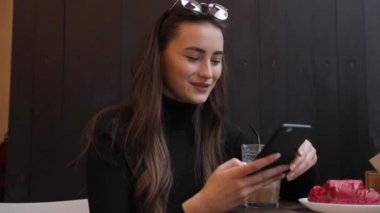 Beyaz gömlek giymiş ve modern akıllı telefon, cep telefonu dışında ağır çekim kısa mesaj yazarak profesyonel kadın işveren kullanarak güzel genç kadın