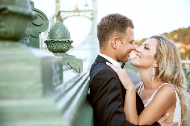 Gelin ve damat kente sokak sarılma. Evlilik çift aşık. Lüks yapay elmas elbise. Sıcak yaz günlerinde.