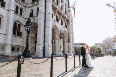 Gelin ve damat kente sokak sarılma. Evlilik çift aşık. Lüks yapay elmas elbise. Sıcak yaz günlerinde.