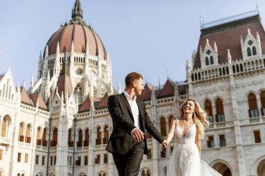 Gelin ve damat kente sokak sarılma. Evlilik çift aşık. Lüks yapay elmas elbise. Sıcak yaz günlerinde.