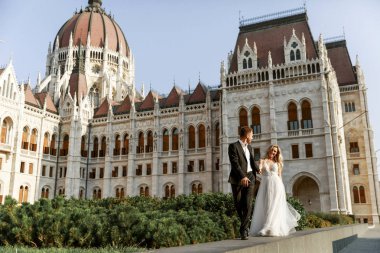 Gelin ve damat kente sokak sarılma. Evlilik çift aşık. Lüks yapay elmas elbise. Sıcak yaz günlerinde.