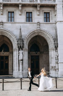 Gelin ve damat kente sokak sarılma. Evlilik çift aşık. Lüks yapay elmas elbise. Sıcak yaz günlerinde.