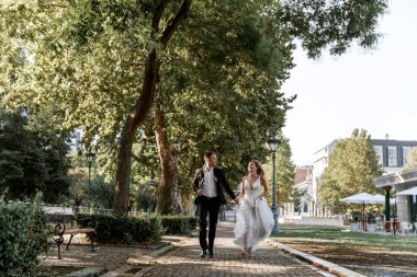 Gelin ve damat kente sokak sarılma. Evlilik çift aşık. Lüks yapay elmas elbise. Sıcak yaz günlerinde.