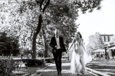 Gelin ve damat kente sokak sarılma. Evlilik çift aşık. Lüks yapay elmas elbise. Sıcak yaz günlerinde.