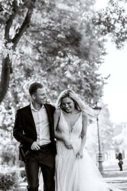 Gelin ve damat kente sokak sarılma. Evlilik çift aşık. Lüks yapay elmas elbise. Sıcak yaz günlerinde.