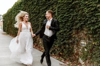 Gelin ve damat kente sokak sarılma. Evlilik çift aşık. Lüks yapay elmas elbise. Sıcak yaz günlerinde.